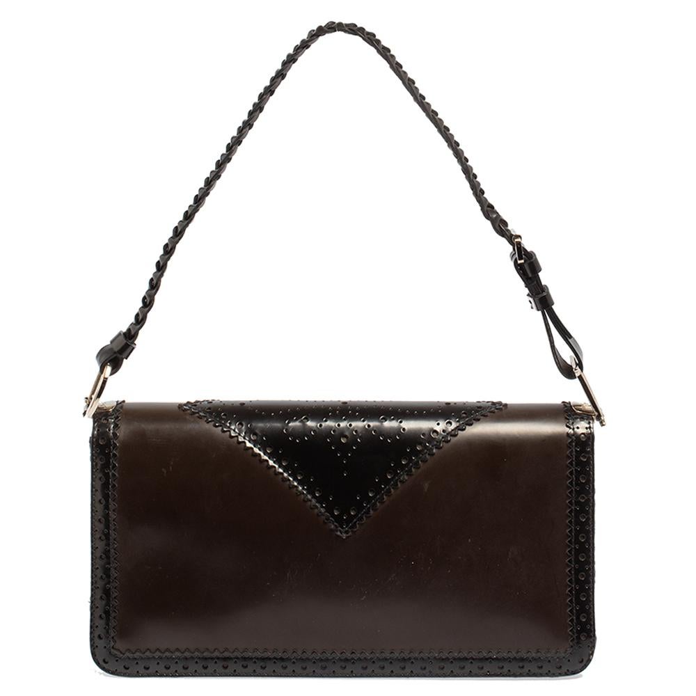 This petite and elegant handbag by Dior is ideal for any occasion. Crafted from leather brogue detailing and Oblique canvas, this bag features a braided leather strap. The interior is lined with luxurious satin and has enough space for