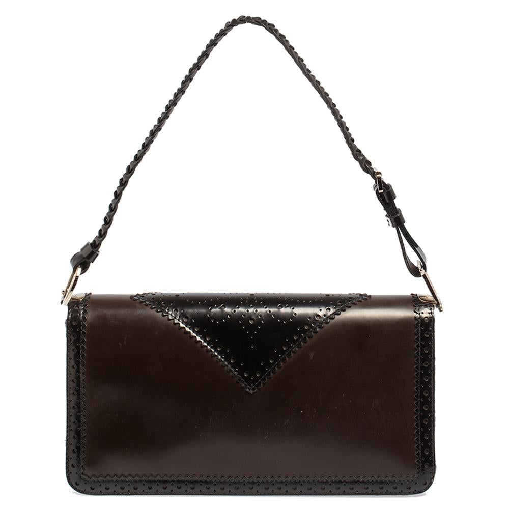 Diese zierliche und elegante Handtasche von Dior ist ideal für jede Gelegenheit. Diese Tasche ist aus Leder mit Brogue-Details und Oblique-Canvas gefertigt und verfügt über einen geflochtenen Lederriemen. Das Innere ist mit luxuriösem Satin