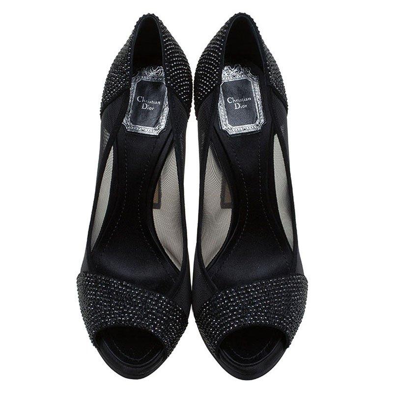 A pair of classic black shoe is a wardrobe staple. Coming from the worldwide renowned fashion house of Dior, this pair is finely designed in a black satin and mesh combination that forms the body. It comes with crystal stud detailing at the vamps