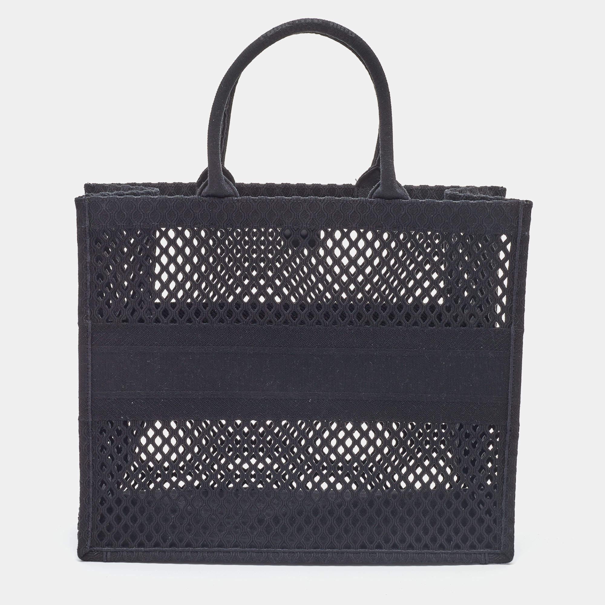 Designed by Maria Grazia Chiuri, the Dior Book Tote is a travel accessory that is one of the most coveted in the fashion world. The large version here is crafted using mesh canvas into a beautiful structure. Two handles, the 'Christian Dior' logo on