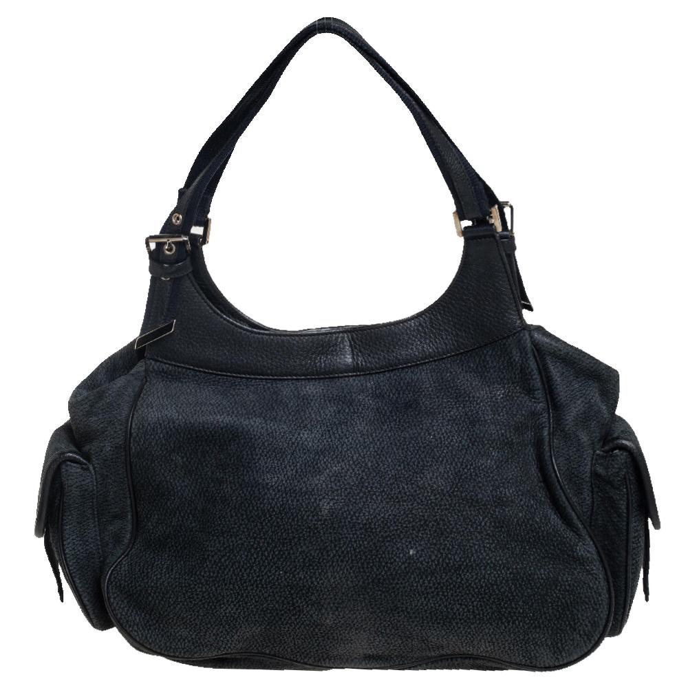 Crafted with nubuck as well as leather and lined with canvas, you will find this Dior bag an ideal companion for all your needs. It features multiple pockets on the exterior and the brand plaque on the front. The interior is spacious and the bag is