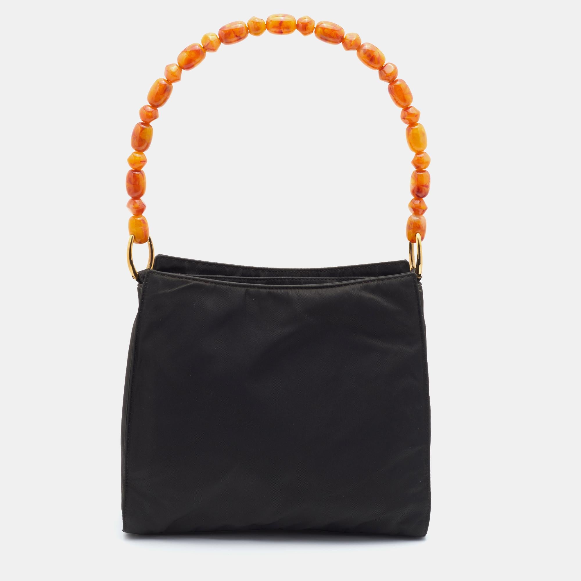 Every well-curated wardrobe deserves a Dior handbag like this one. A practical and elegant everyday bag in black nylon, held by a stunning beaded handle. The spacious interior is lined with fabric.

