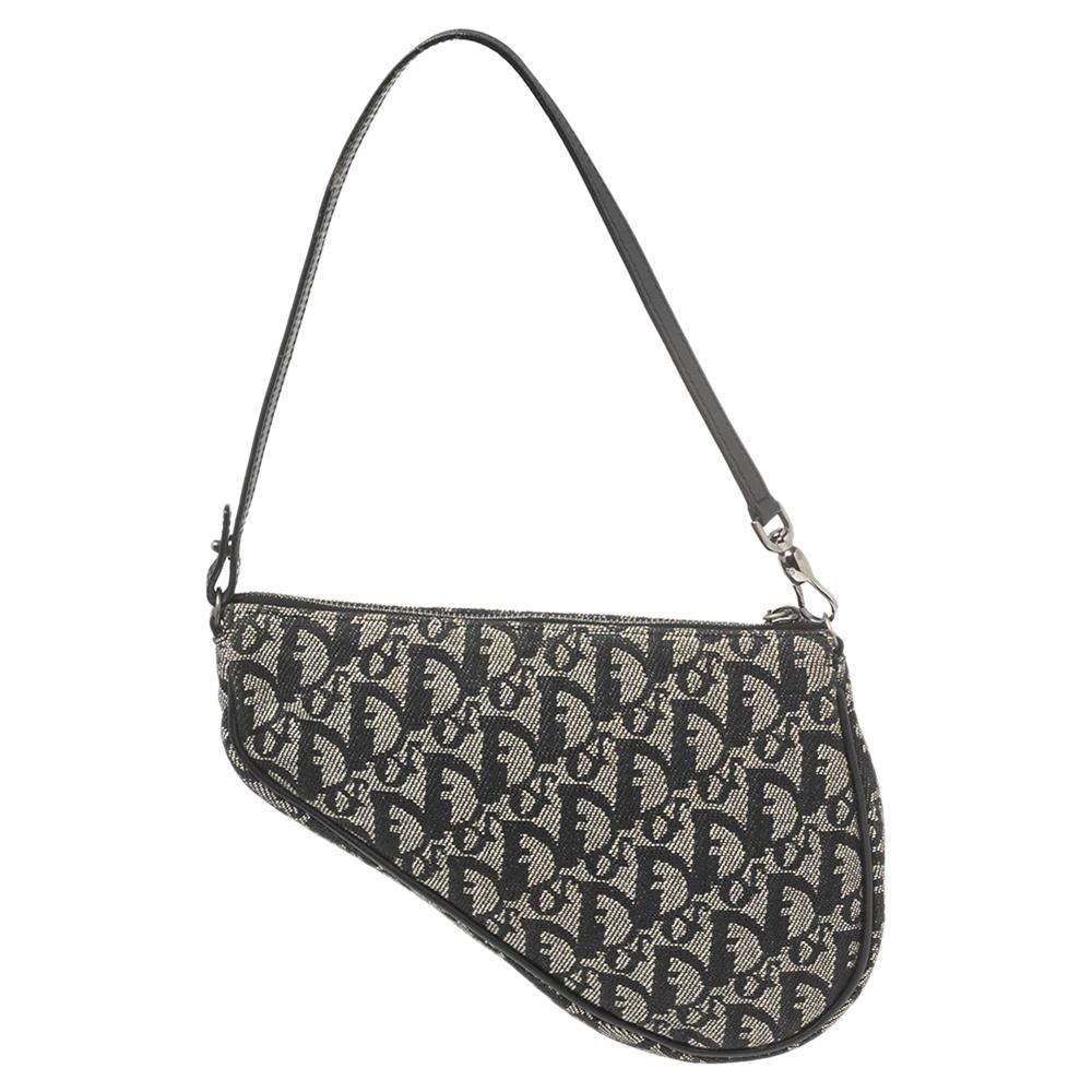 Owing to its uniquely-crafted silhouette and timeless elegance, the Saddle Pochette bag from Dior remains one of the most sought-after designs of the brand. This version is carved using black Oblique canvas and leather. It is complete with a