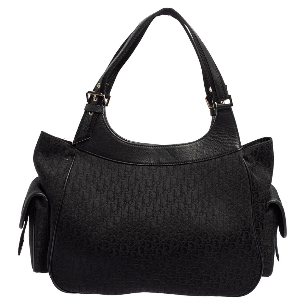 Verleihen Sie Ihrem Look einen luxuriösen Touch mit dieser Street Chic-Tasche von Dior. Sie ist aus schrägem Canvas gefertigt und mit Lederbesätzen sowie silberfarbener Hardware ausgestattet. Sie hat eine Logoplakette und zwei Pattentaschen auf der