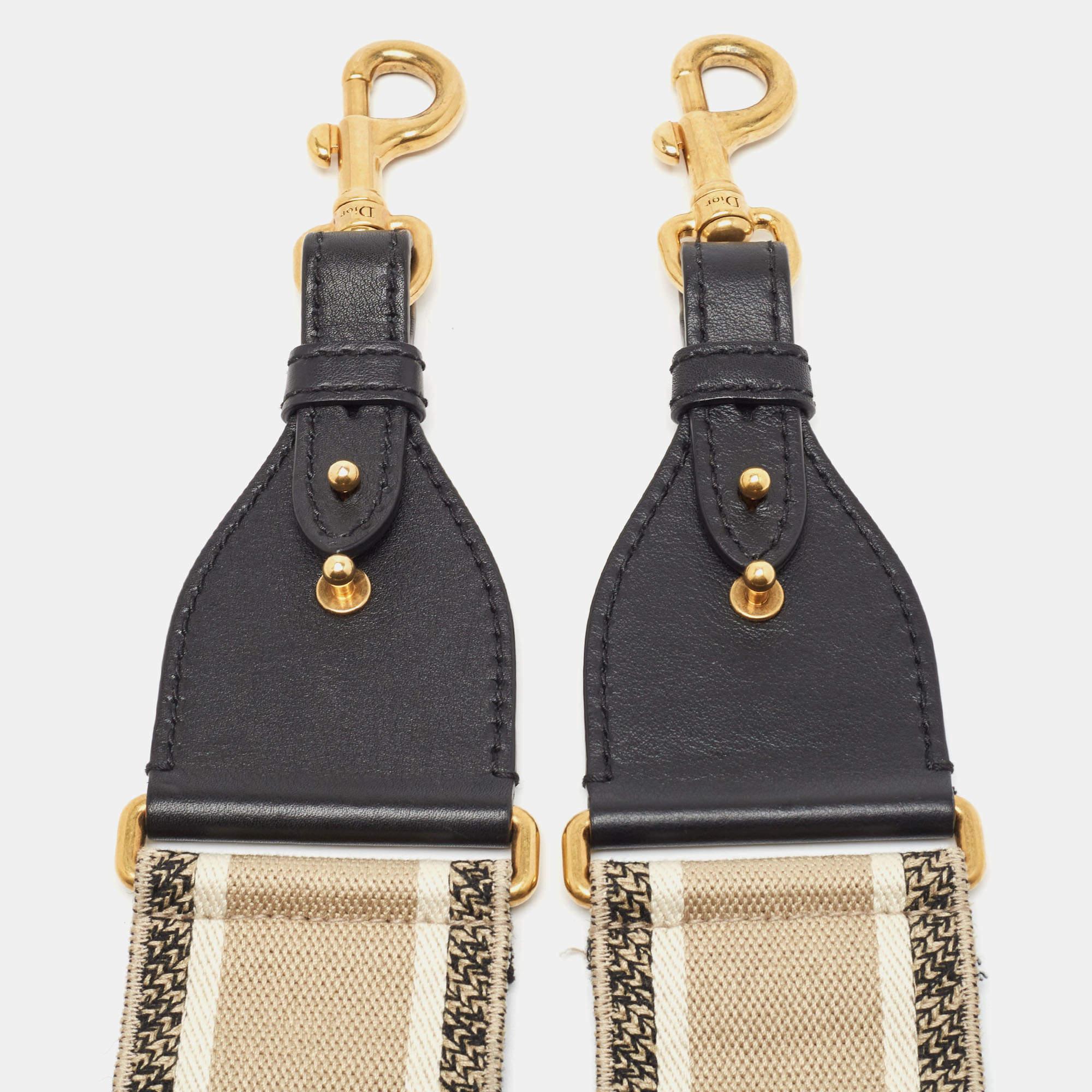 Dior bringt Ihnen diesen superschicken Schulterriemen, den Sie mit Ihrer großen Handtaschensammlung zur Schau stellen können. Der Riemen ist aus besticktem Segeltuch und Lederbesätzen gefertigt. Er ist mit zwei Metallverschlüssen versehen, mit denen