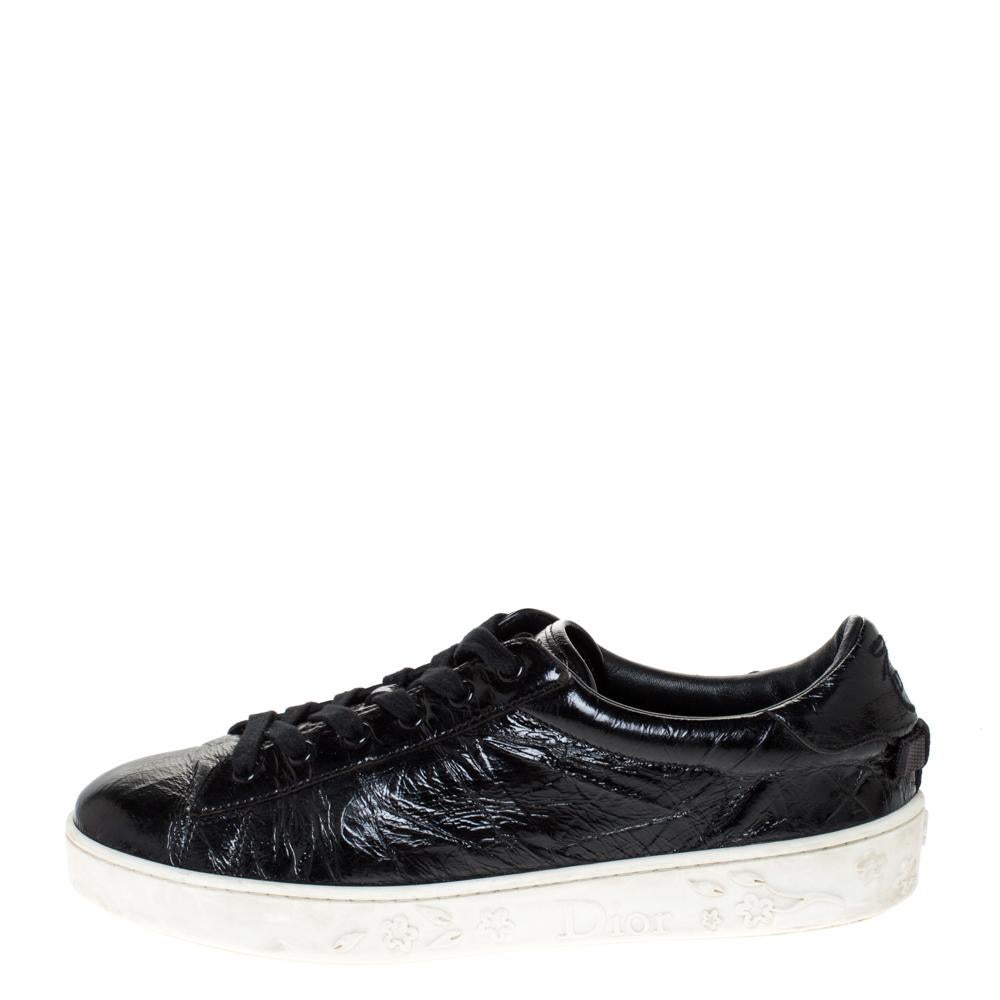 Bold and edgy, these Dior sneakers are for women who like a groovy and fun style. Featuring a crinkled patent leather body, these black sneakers come with a low-top silhouette and are detailed with lace-ups on the vamps. Wear these sneakers with