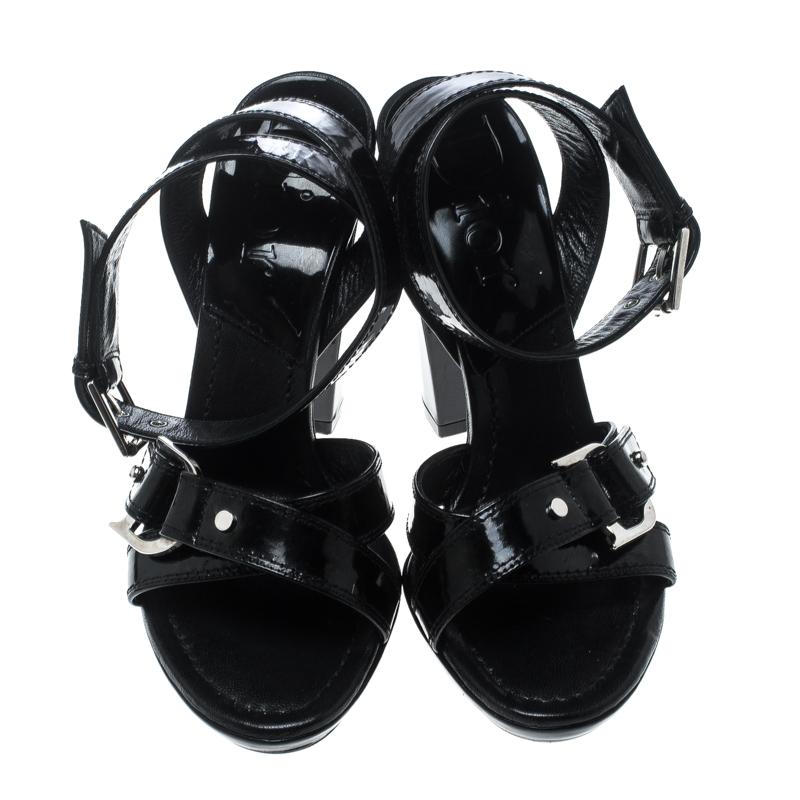 In a lovely design of black patent leather comes these sandals from Dior for you to strut in glamour. The sandals feature crisscross straps on the front accented with silver-tone buckles, open toes and are balanced on 11.5 cm heels to give you the