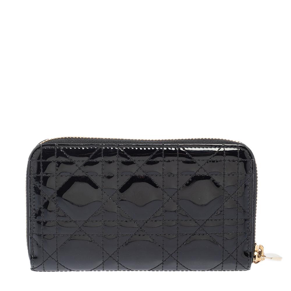 This Lady Dior wallet is conveniently designed for everyday use. Crafted from patent leather, the exterior has a quilted Cannage pattern and a zipper with DIOR letter charms on the zipper pull. The leather and nylon-lined interior houses multiple