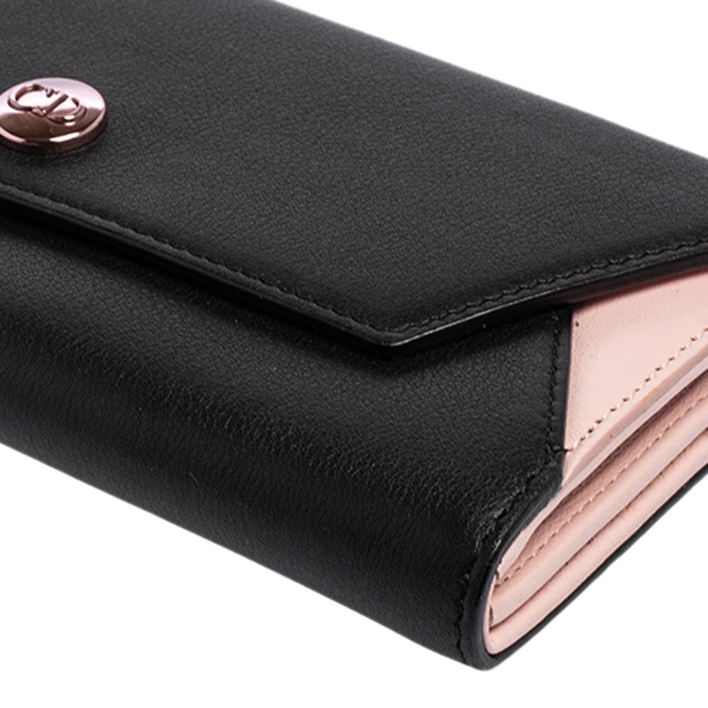 This Envelope wallet from the House of Dior, with its chic style and skilled design, easily captures your attention. It has been designed using black-pink leather on the exterior with a pink-toned CD accent embellishing the front. It comes with a