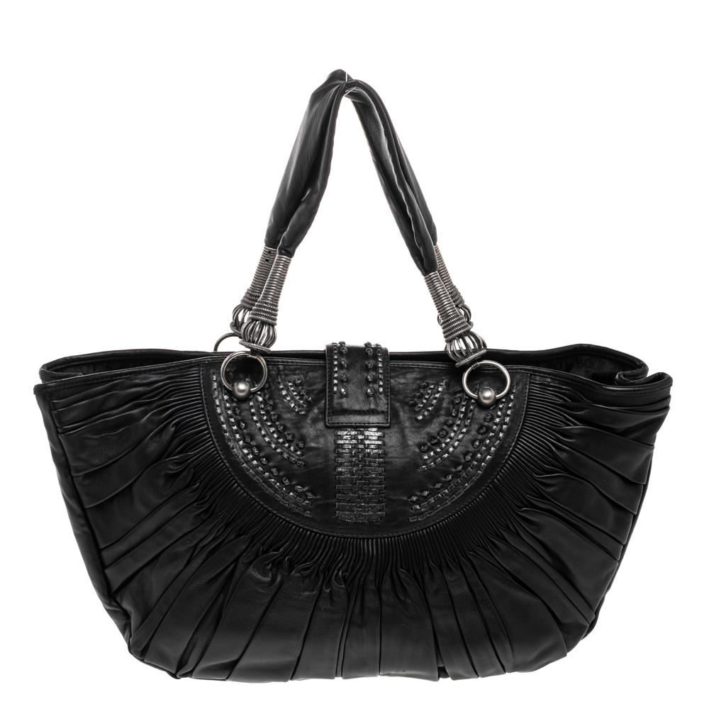 Expertly crafted from leather into a unique silhouette, this tote from the house of Dior exhibits an exquisite design. It has a spacious interior lined with the finest canvas and equipped with a zipped pocket. With an impressive pleated detail all