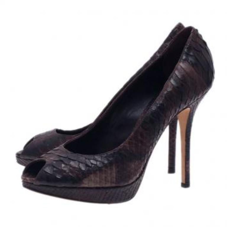 ¡Estas siluetas de puntera abierta crean una forma fácil y chic de ampliar tu vestuario durante todo el año! Confeccionados en piel de pitón brillante de color negro, estos zapatos de salón de Dior cuentan con plataformas autocubiertas y peep toes. 