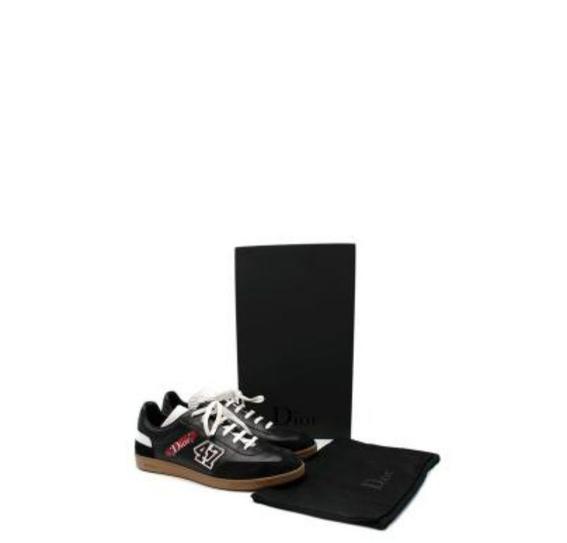Dior Black & Red Leather Skateboard Sneakers
 
 - Black leather upper with varsity-style lettering patch and skateboard motif appliques
 - Lace-up
 - Natural rubber sole
 
 Materials 
 Leather and suede 
 Rubber sole 
 
 Made in Italy 
 
 PLEASE