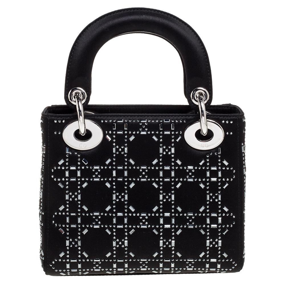 The Lady Dior tote is a Dior creation that has gained recognition worldwide and is today a coveted bag that every fashionista craves to possess. This black tote has been crafted from satin, and it carries the signature Cannage pattern featuring