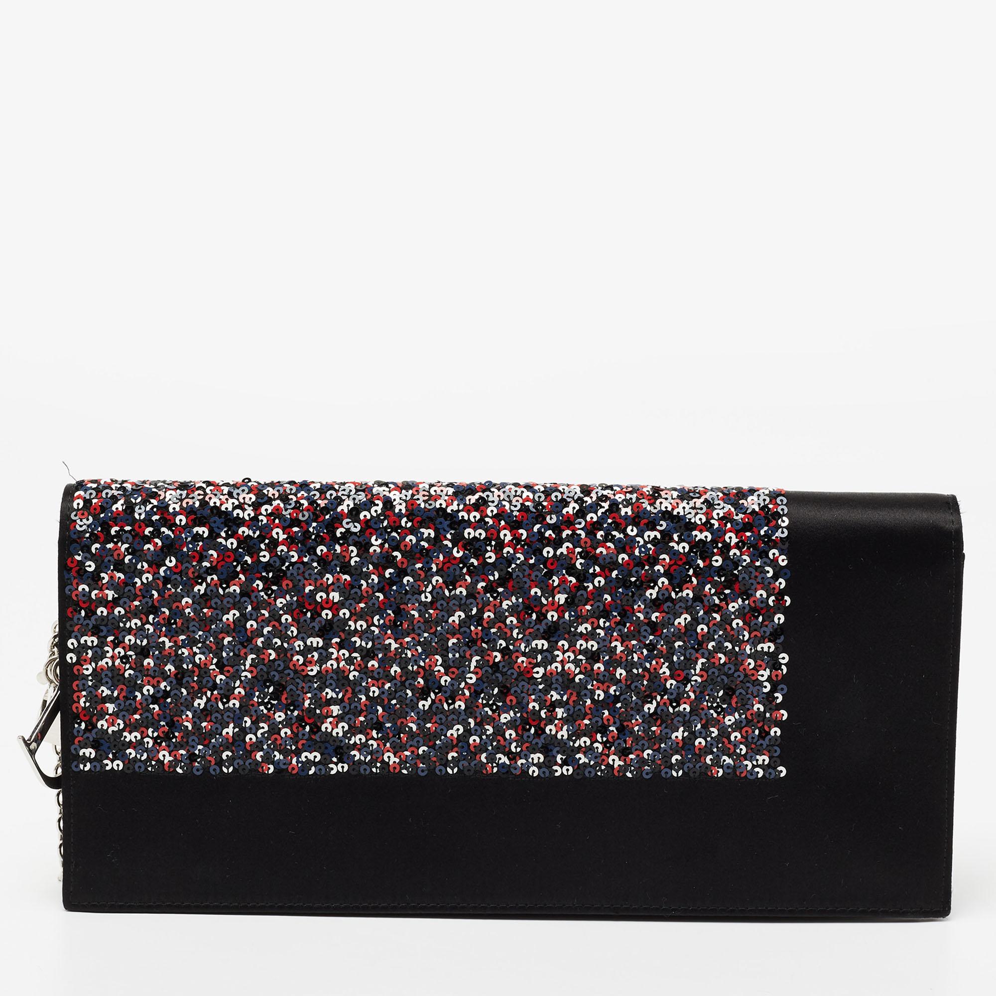Injectez la signature esthétique de Dior dans votre tenue en l'accessoirisant avec cette pochette. Confectionné en satin et paillettes, ce modèle Lady Dior a été rehaussé d'accents argentés, et les breloques de la marque sur le devant témoignent de