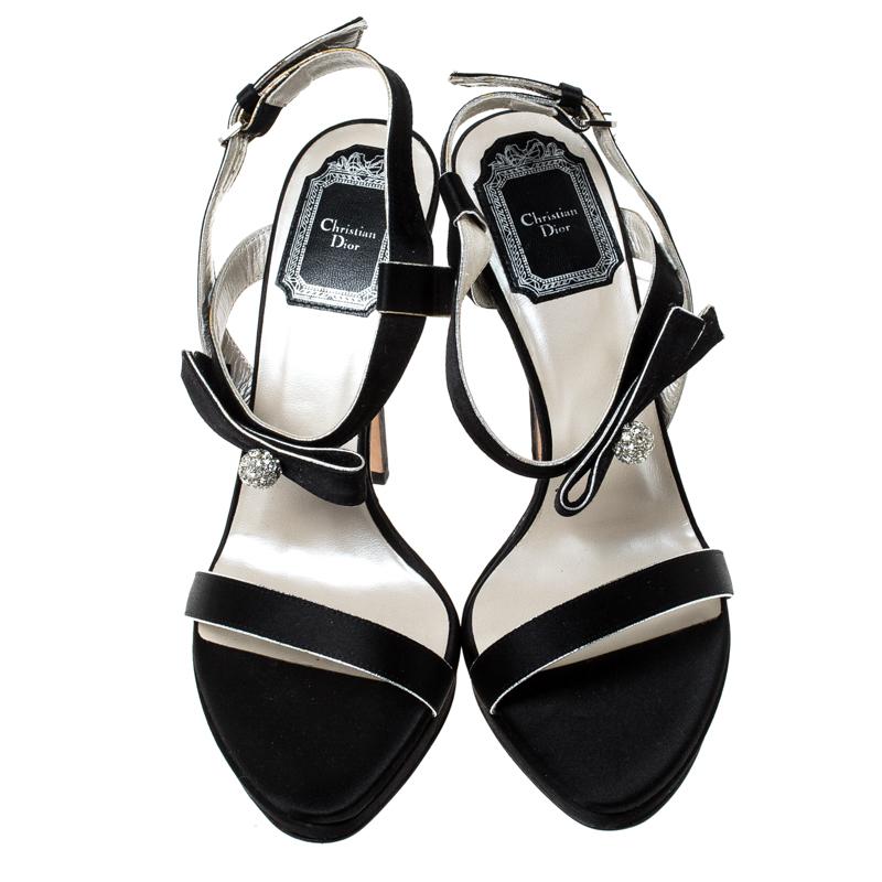 Crafted to beautifully frame your feet, these Dior sandals are a versatile pair to add to your collection. It features black satin straps and set on slender heels. It is secured with a buckle closure for a secured fit. Style with dresses, skirts or