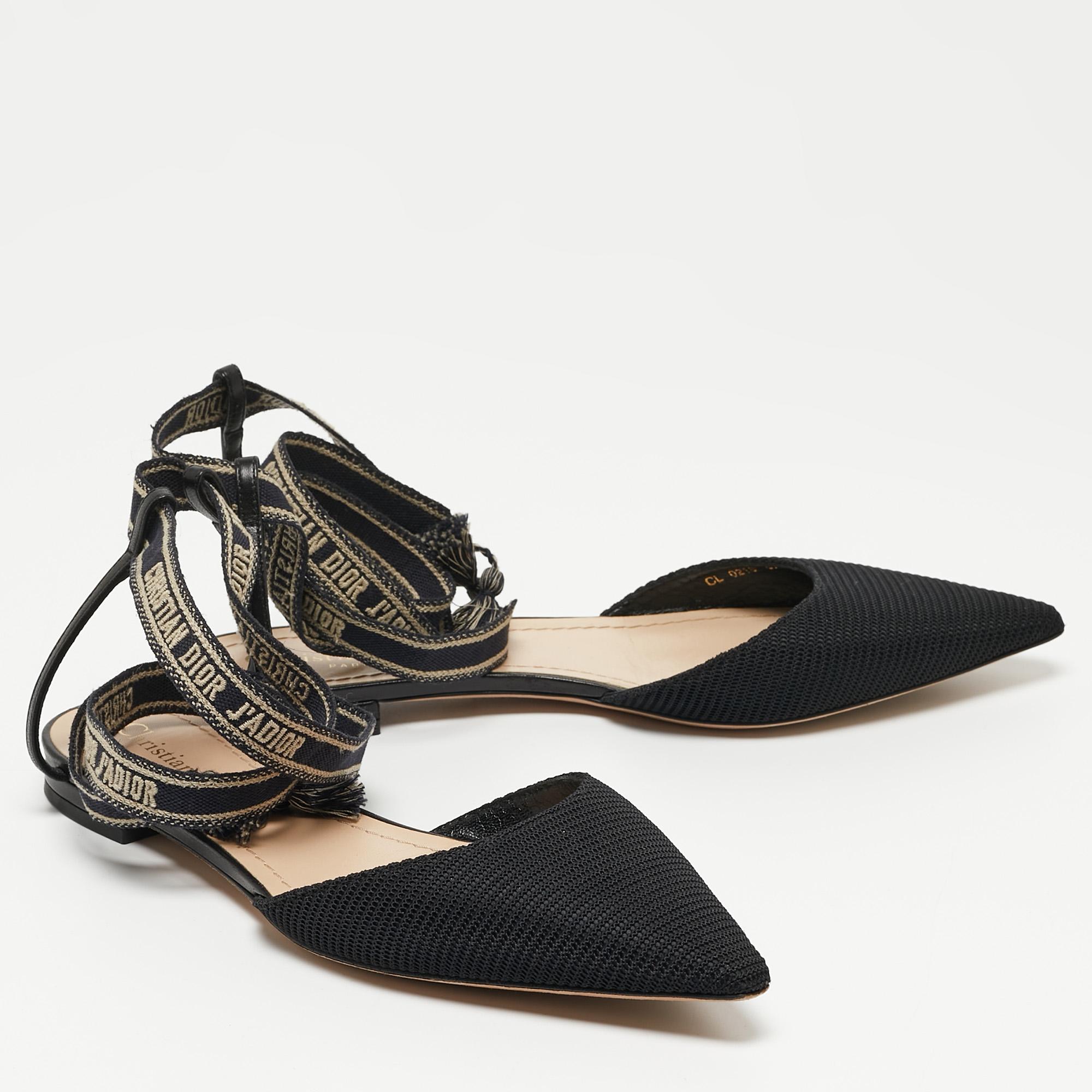 The J'adior collection from the House of Dior is one of the most beloved and celebrated creations of the label. These J'adior flats are made from black technical fabric and are adorned with logo-printed ankle wrap feature. Sleek and feminine, let