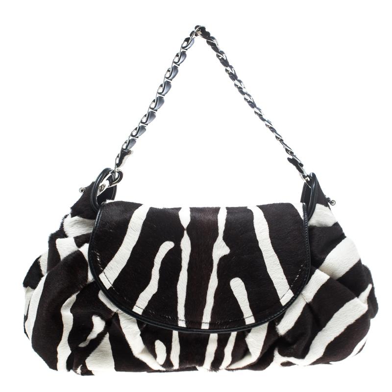 Classic, chic and very sophisticated, this Dior hobo is sure to enchant and cast a spell on you. The creation is crafted from calf hair and features a black and white animal print on it. It flaunts a front flap closure that is detailed with