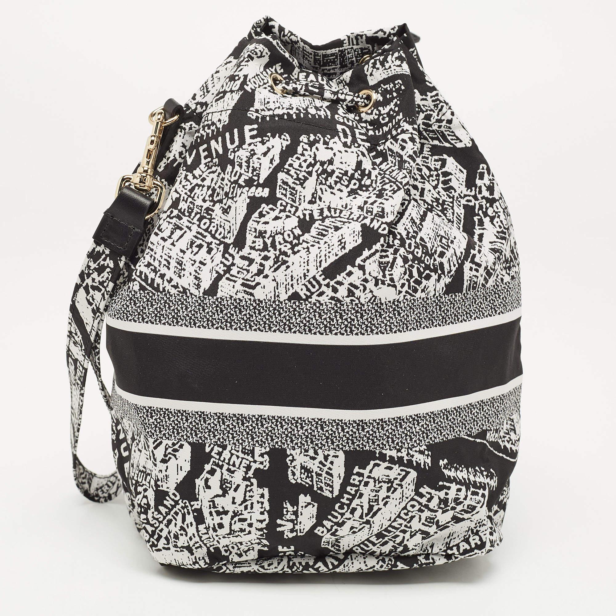 The Dior Diortravel Pouch is a chic and compact accessory featuring the Plan De Paris motif. Crafted from durable nylon, it boasts a black and white color scheme, exemplifying sophisticated Parisian style. Ideal for organizing essentials with a