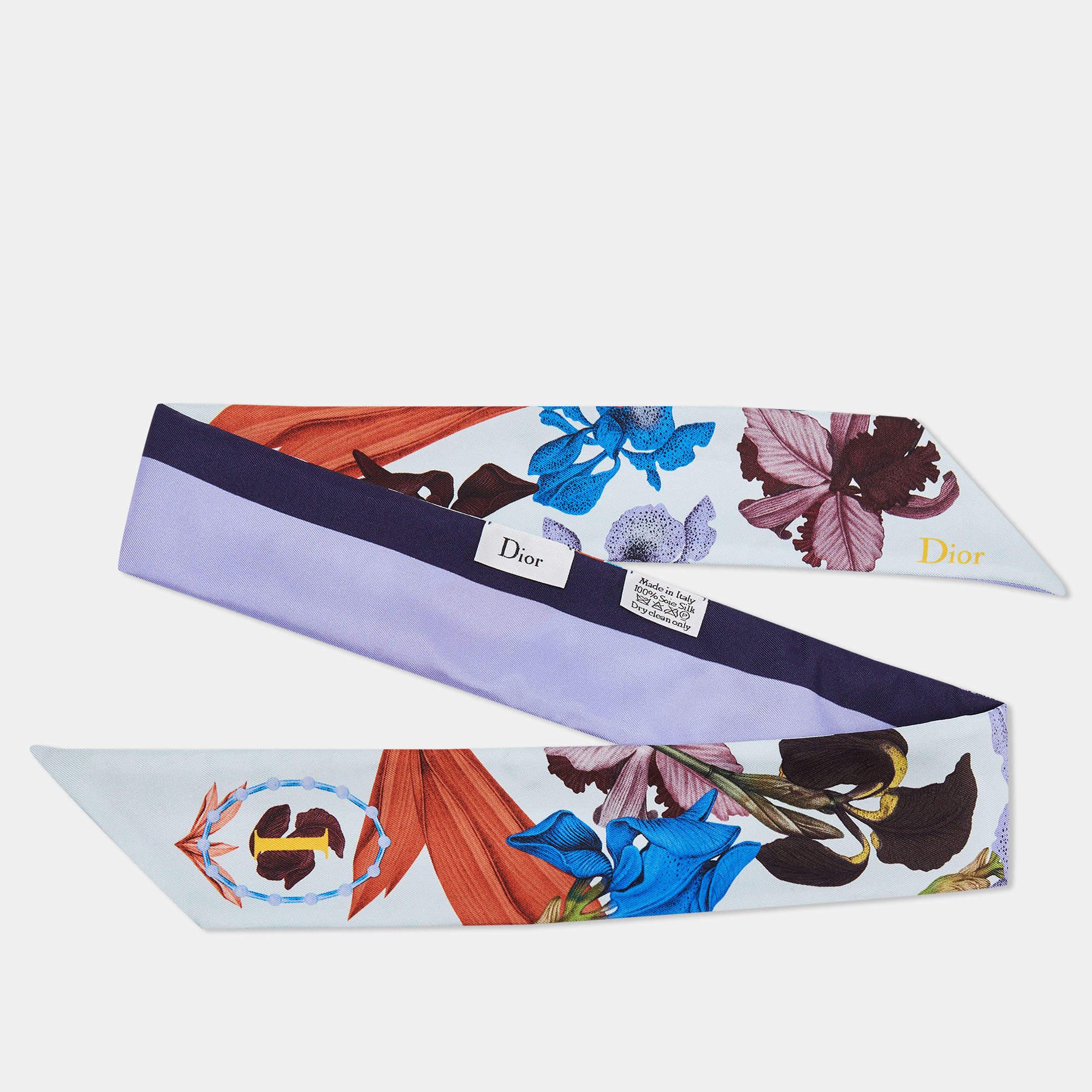 The Dior Blue ABCDior 'I' for Iris Floral Print Silk Mitzah Scarf is a luxurious accessory that features a stunning floral print with blue hues. Made from high-quality silk, it is adorned with the letter 'I' and is a versatile, elegant addition to