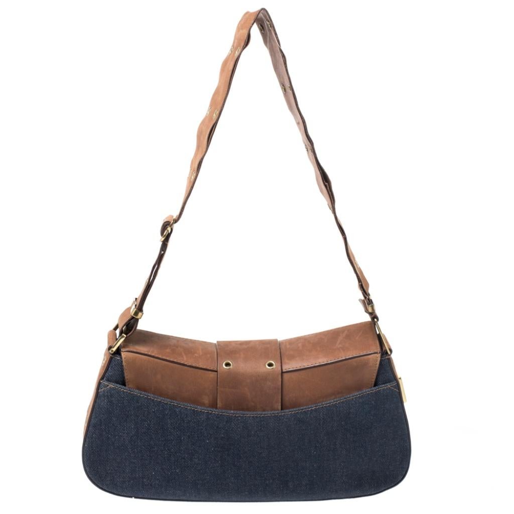 To make a remarkable style statement, this handbag by Dior is just what you need. Crafted in Italy, it is made of quality denim fabric and leather. It comes in lovely hues of blue and brown. This chic shoulder bag is held by a single handle, front
