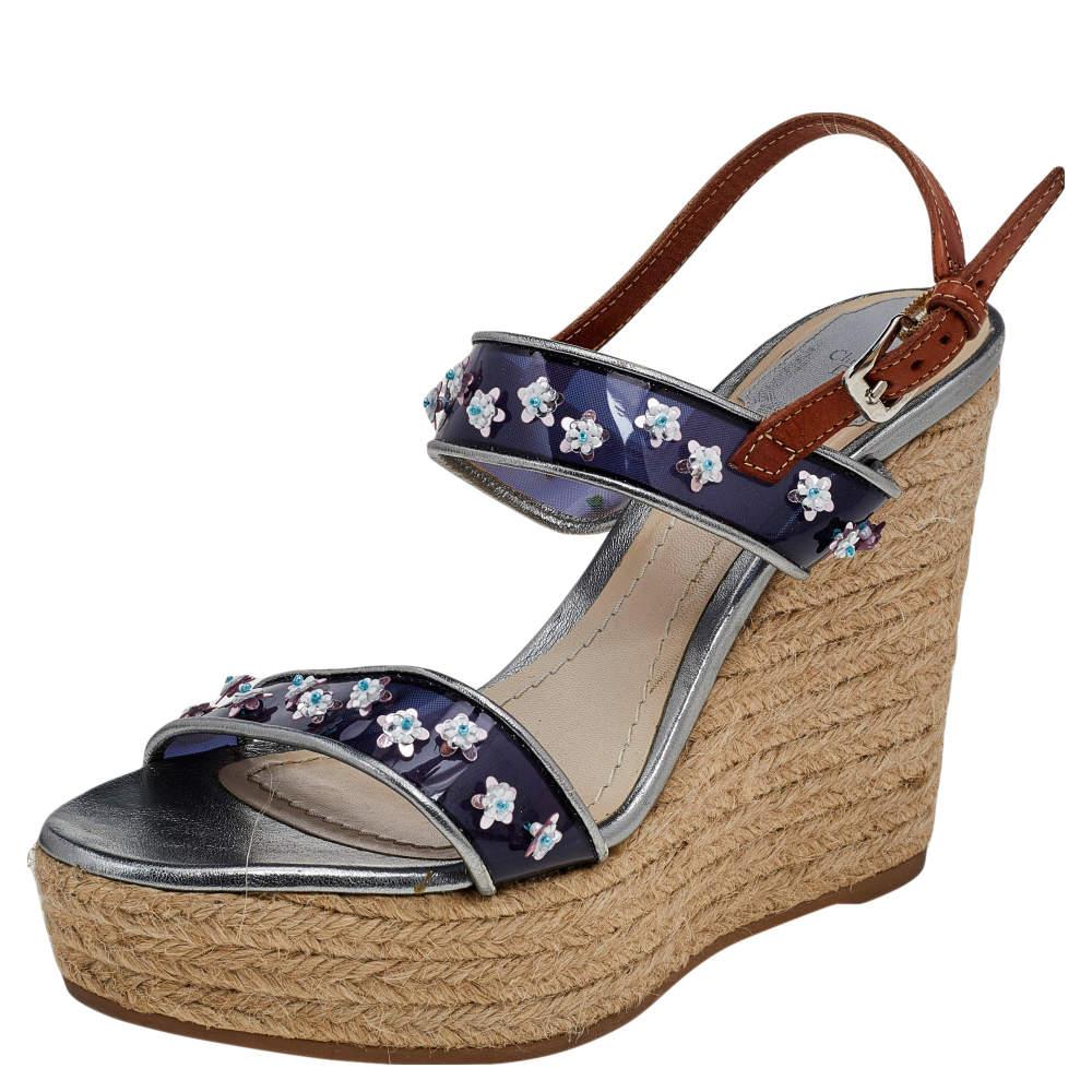These sandals from Dior grant you chic, feminine vibes! They are crafted using blue-brown PVC and leather on the exterior and feature floral-embellished straps on the upper. They are completed with espadrille wedge heels. 