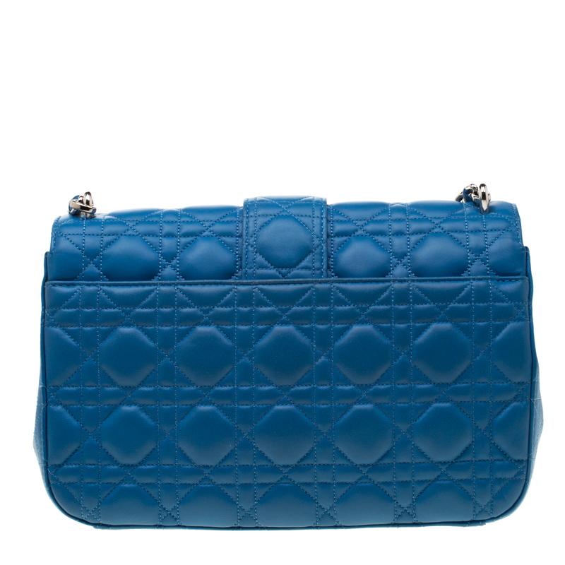 Flap bags like this Miss Dior will never go out of style. Crafted from leather, this Dior flap bag features a blue Cannage exterior and a leather and chain woven shoulder strap. The front flap has a silver-tone lock that opens to a leather-lined