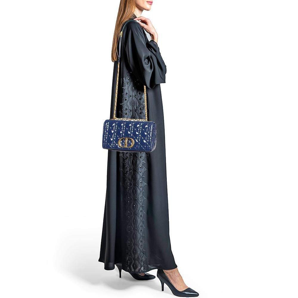 Le sac Dior Caro témoigne de l'esthétique intemporelle et intrinsèquement moderne de la marque. Nommé d'après la sœur de Christian Dior, Catherine, ce sac célèbre la femme d'aujourd'hui. Il a été confectionné en cuir verni et porte les détails de la