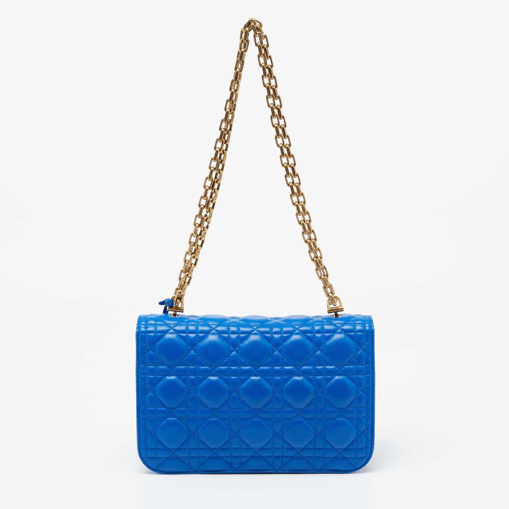 This Dioraddict shoulder bag from the house of Dior is both elegant and fashionable. It is crafted from beautiful blue, Cannage quilted leather, with a gold-tone lock closure perched on the front. It has a suede-lined interior and a slender chain
