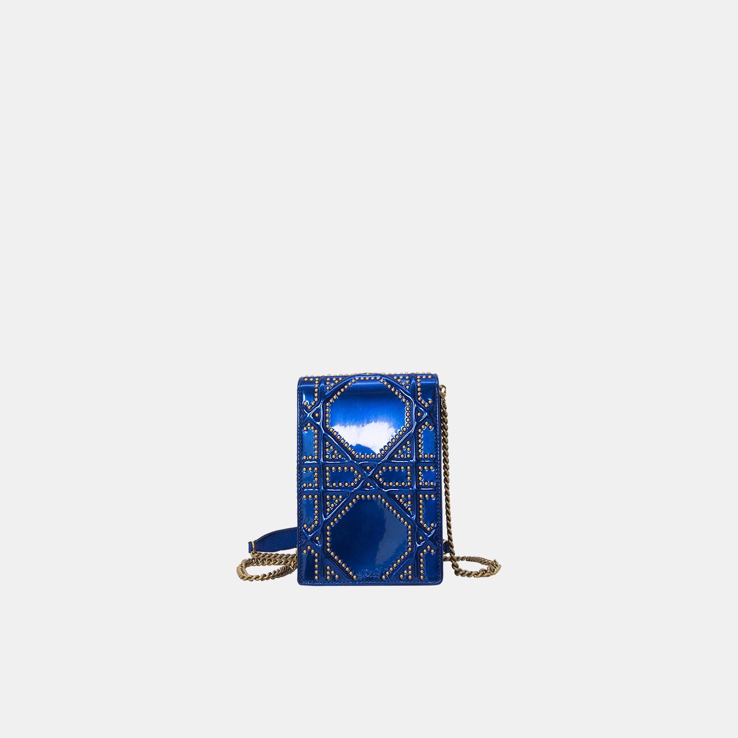 The Dior Blue Diorama Vertical Leather Clutch Bag is a stunning accessory that embodies the fusion of contemporary flair with classic elegance. This piece, originating from the prestigious house of Christian Dior, boasts a vibrant electric blue