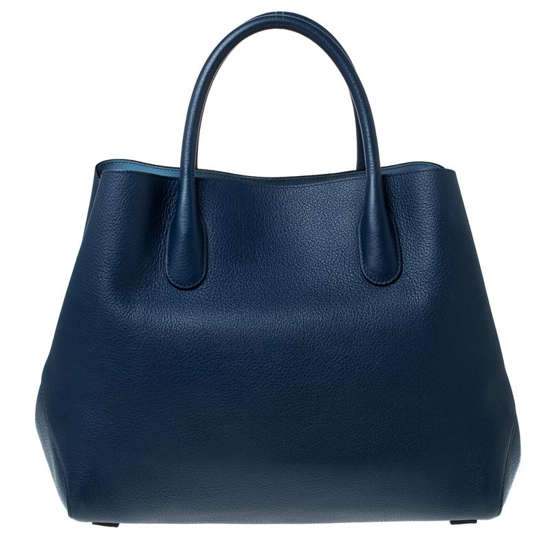 This stunning Open Bar bag is high on appeal and style. Dazzling in a classy blue, the bag is crafted from grained leather and features two rolled handles and a shoulder strap. The top leads way to a leather-lined interior with enough space for your