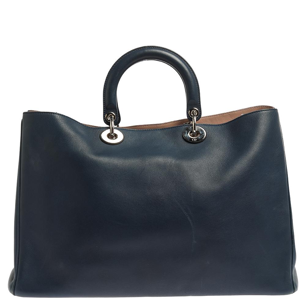 The Diorissimo shopper tote from Dior is a piece that has never gone out of style. The leather bag comes in an enticing blue shade with silver-tone hardware and Dior letter charms. It features double top handles, a shoulder strap, and protective