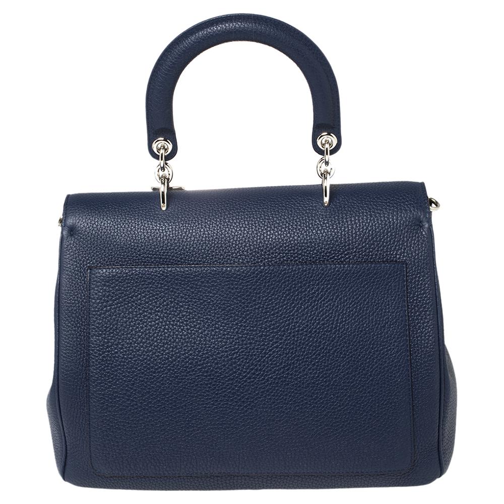 This Be Dior bag from the house of Dior is sure to add sparks of luxury to your wardrobe! It is crafted from leather and features a chic silhouette. It flaunts a single rolled top handle with attached 'DIOR' letter charms and comes equipped with