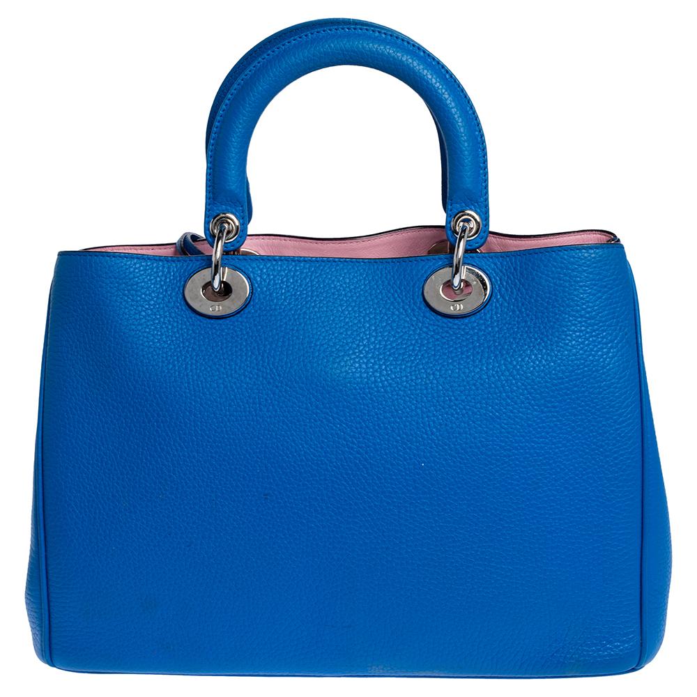 The Diorissimo shopper tote from Dior is a piece that has never gone out of style. The leather bag comes in a pleasing blue shade with silver-tone hardware and Dior letter charms. It features double top handles, a small pouch and protective feet at