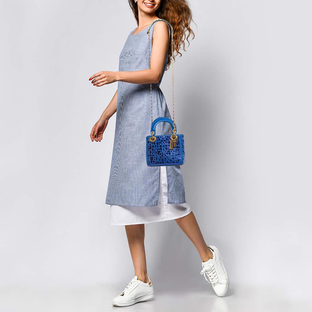 The Dior Mosaic of Mirrors Lady Dior tote exudes elegance with its intricate mosaic design crafted from luxurious blue leather. Reflective mirrors add a touch of glamour, while the iconic Lady Dior silhouette offers timeless sophistication. This