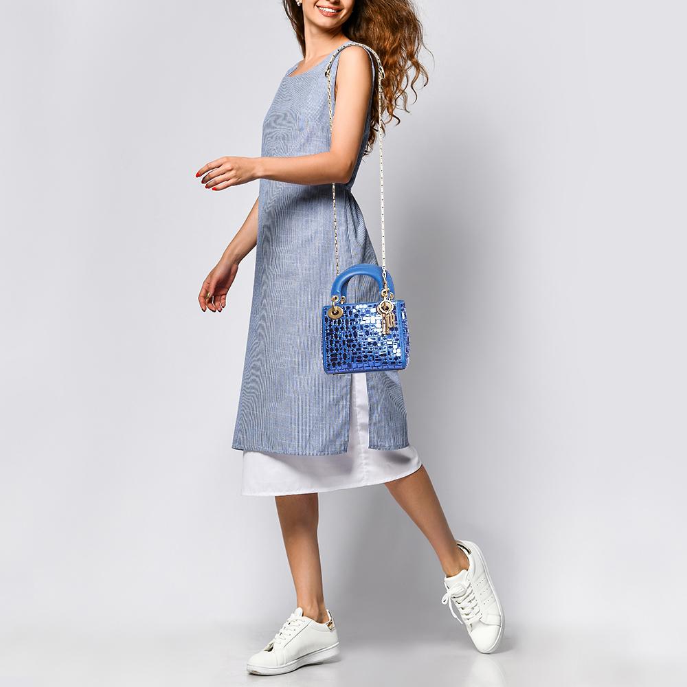 The Dior Mosaic of Mirrors Lady Dior tote exudes elegance with its intricate mosaic design crafted from luxurious blue leather. Reflective mirrors add a touch of glamor, while the iconic Lady Dior silhouette offers timeless sophistication. This mini