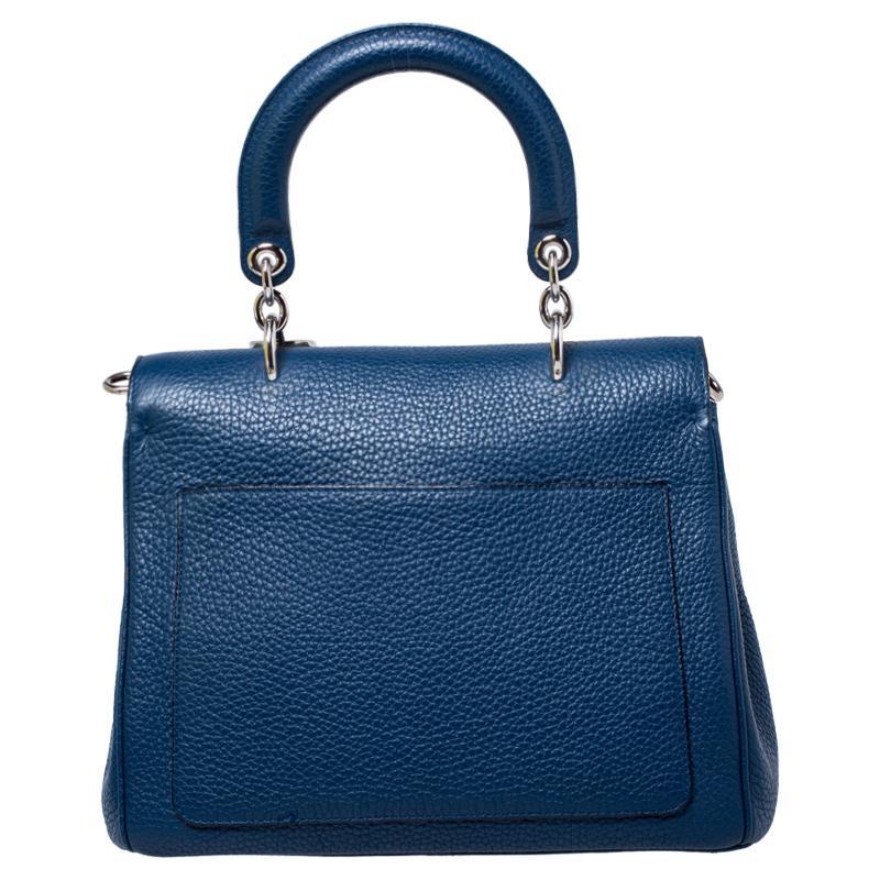 This Be Dior bag from the house of Dior is sure to add sparks of luxury to your wardrobe! It is crafted from leather and features a chic silhouette. It flaunts a single rolled top handle with attached 'DIOR' letter charms and comes equipped with