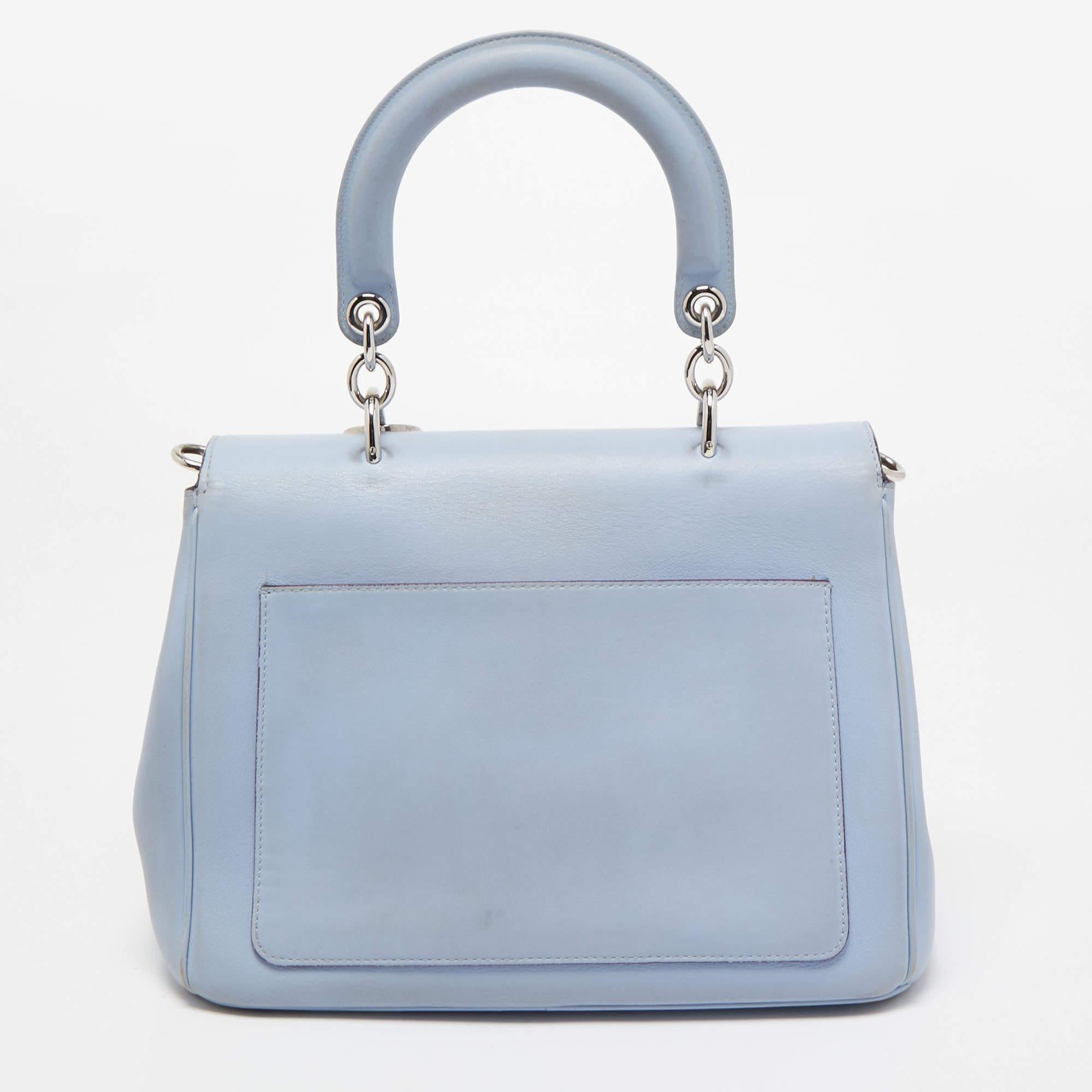 This Be Dior bag from the House of Dior is sure to add sparks of luxury to your wardrobe! It is crafted using light blue leather on the exterior, with the signature D.I.O.R charms embellishing the front. It has a top handle, silver-toned hardware,
