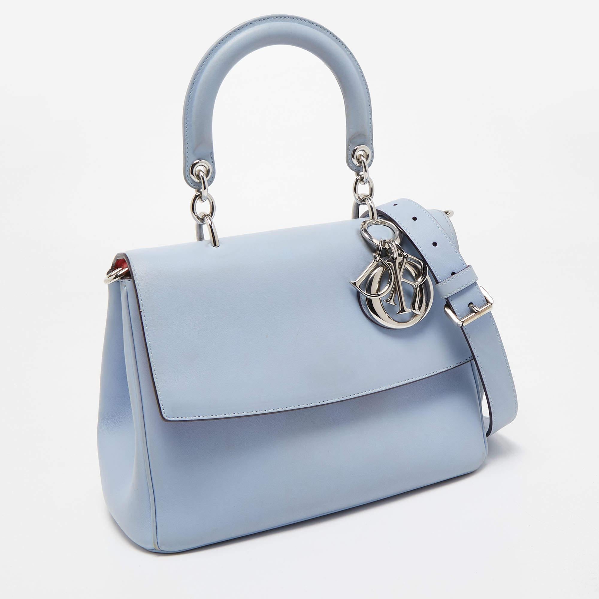This Be Dior bag from the House of Dior is sure to add sparks of luxury to your wardrobe! It is crafted using light blue leather on the exterior, with the signature D.I.O.R charms embellishing the front. It has a top handle, silver-toned hardware,