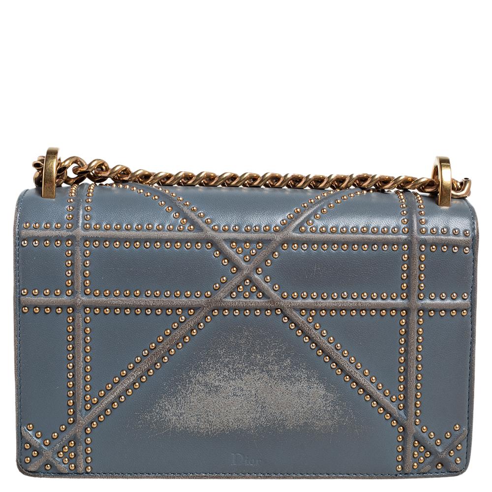 This Diorama bag is simply breathtaking! From its structured shape to its artistic craftsmanship, the bag sweeps us off our feet. It has been crafted from blue leather and covered in the brand's signature Cannage pattern. A magnetic closure on the