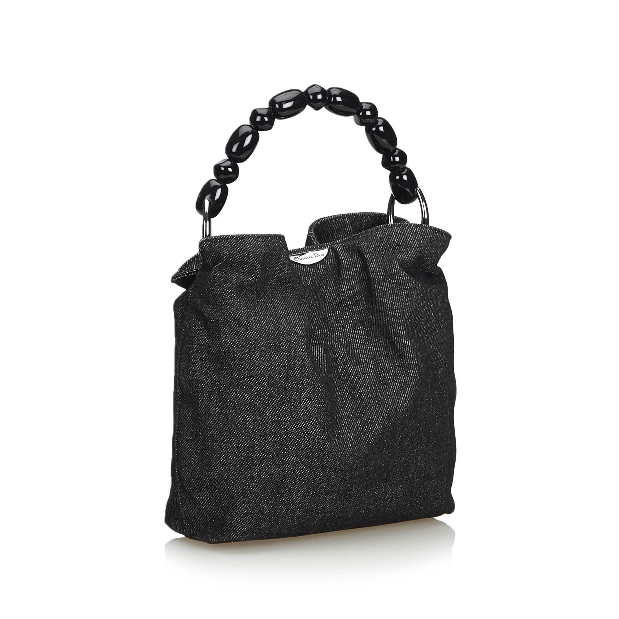 The Malice handbag features a denim body, a plastic handle in pearl detail, an open top with a magnetic closure, and an interior slip pocket. It carries as AB condition rating.

Inclusions: 
This item does not come with