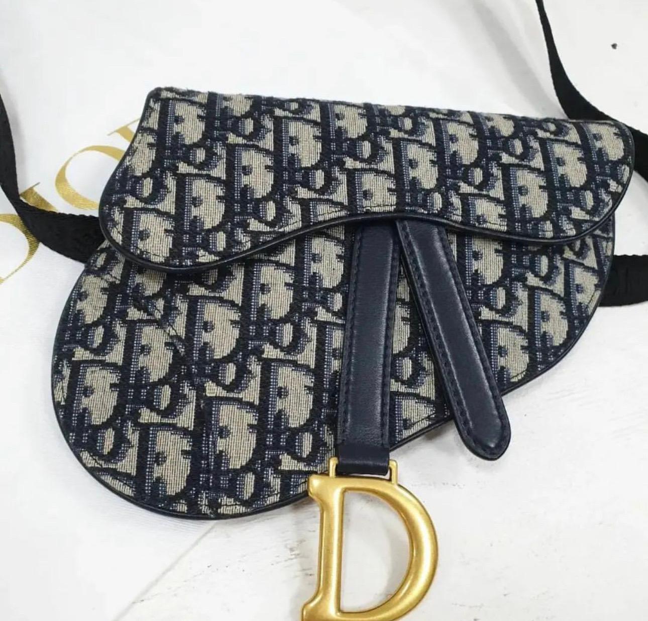 Iconic Saddle bag. 
The design is fully embroidered with the House's hallmark blue Dior Oblique motif. 
The legendary style features a Saddle flap and a D stirrup clasp on a magnetic pull, as well as an antique gold-finish metal CD signature on each