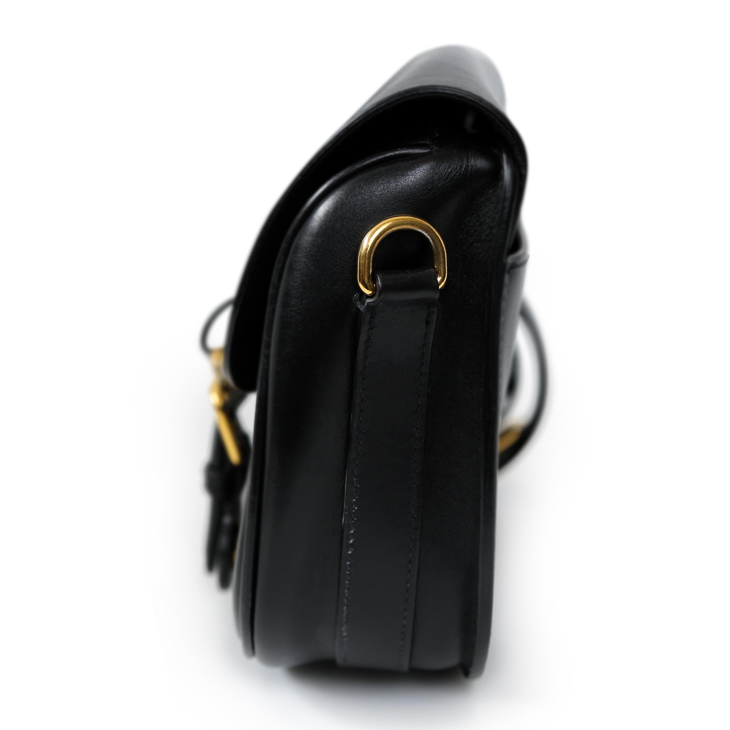 Die mittelgroße Tasche Bobby von Dior ist aus glattem schwarzem Leder gefertigt und strahlt raffinierte Eleganz aus. Diese Tasche ist perfekt für jede Gelegenheit und hat ein schickes und minimalistisches Design. Trotz kleiner Kratzer auf der