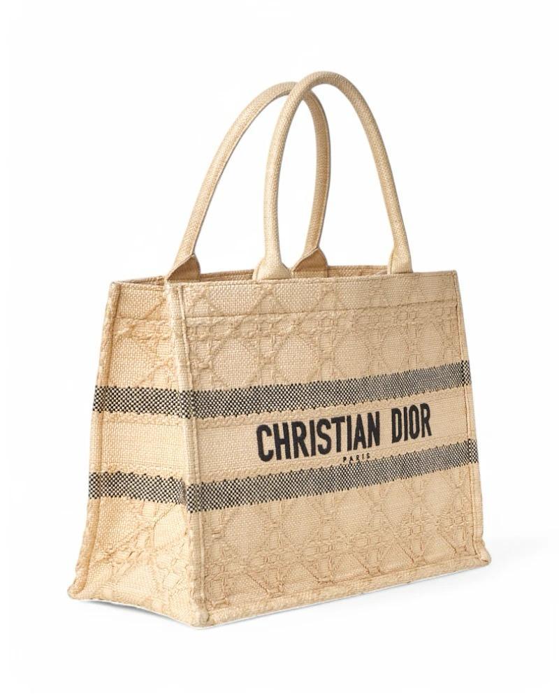 Dior Designertasche, Book Tote Modell in Größe Medium, aus Bast in Beige. Sie hat keinen Verschluss, ist innen mit Ton-in-Ton-Raffia gefüttert und sehr geräumig. Ausgestattet mit einem doppelten Griff, für bequemes Tragen mit der Hand oder dem Arm.
