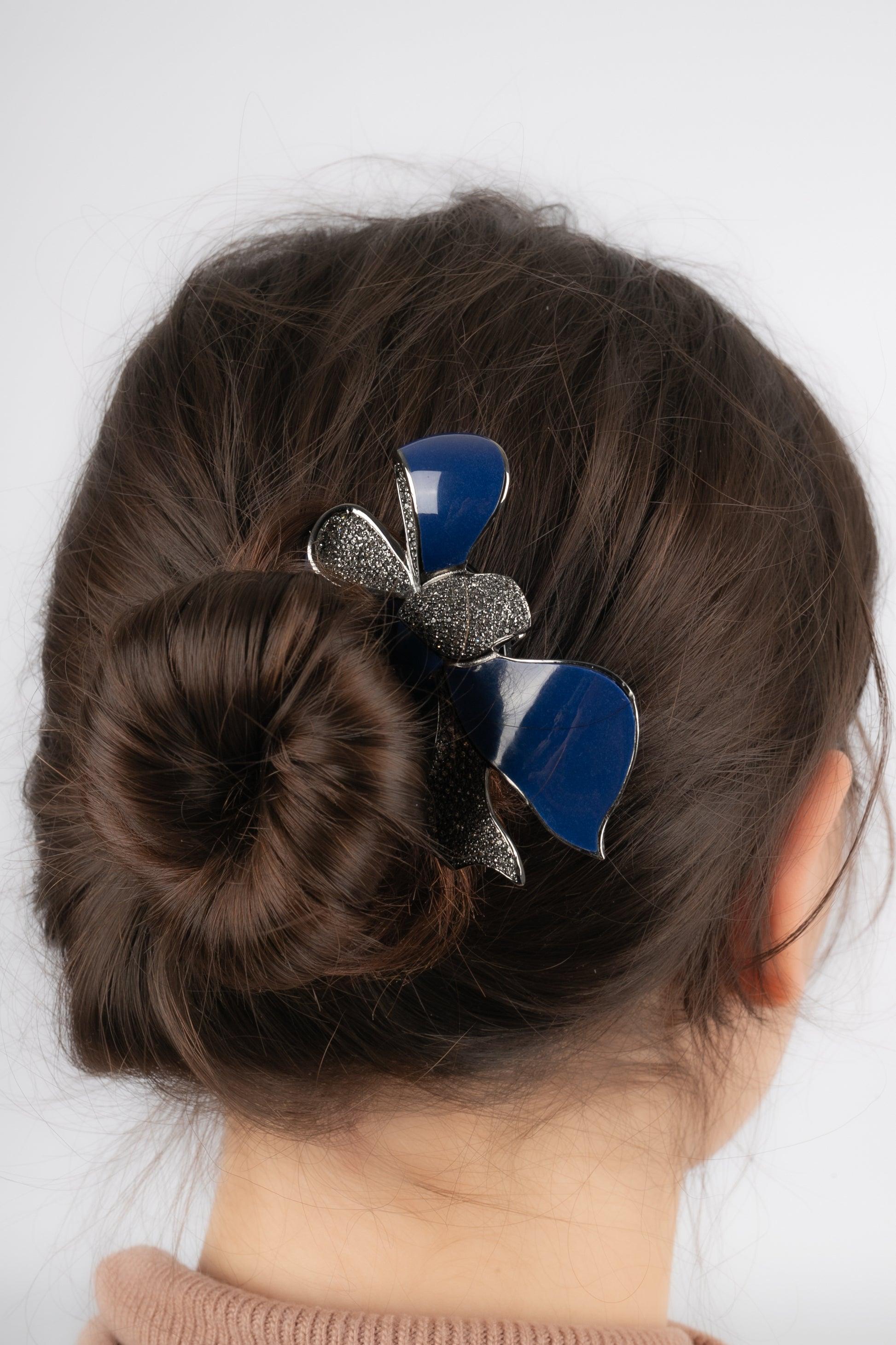Dior - Dunkel-silbriger Metallkamm mit Bakelit, der eine emaillierte und mit Strasssteinen verzierte Schleife darstellt. Schmuck aus den 2000er Jahren.

Zusätzliche Informationen:
Zustand: Sehr guter Zustand
Abmessungen: Länge: 13 cm - Breite: 7