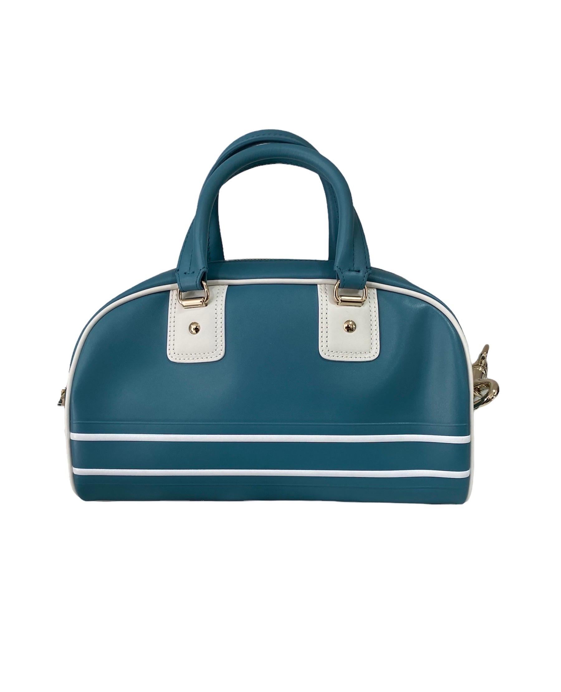 The Dior Vibe bowling bag with zip, designed by Maria Grazia Chiuri, is back in a new version that combines the canons of sportswear with the sartorial spirit of the Maison. Made of smooth blue calfskin, it is decorated with the “CHRISTIAN DIOR