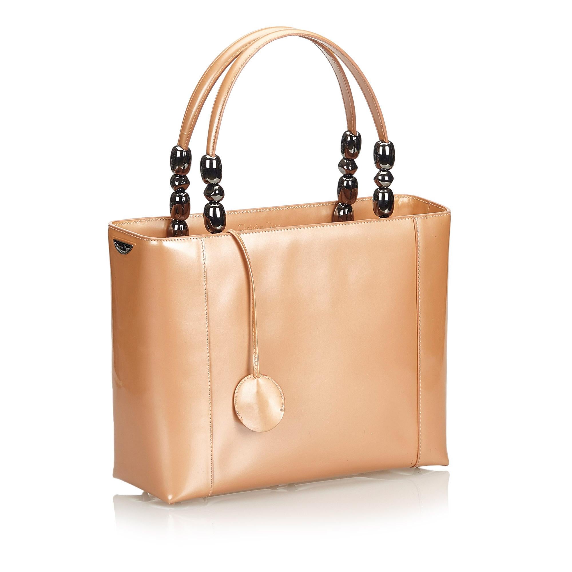 The Malice handbag features a patent leather body, flat leather handles with silver-tone hardware, a top zip closure, and an interior zip pocket. It carries as B+ condition rating.

Inclusions: 
This item does not come with