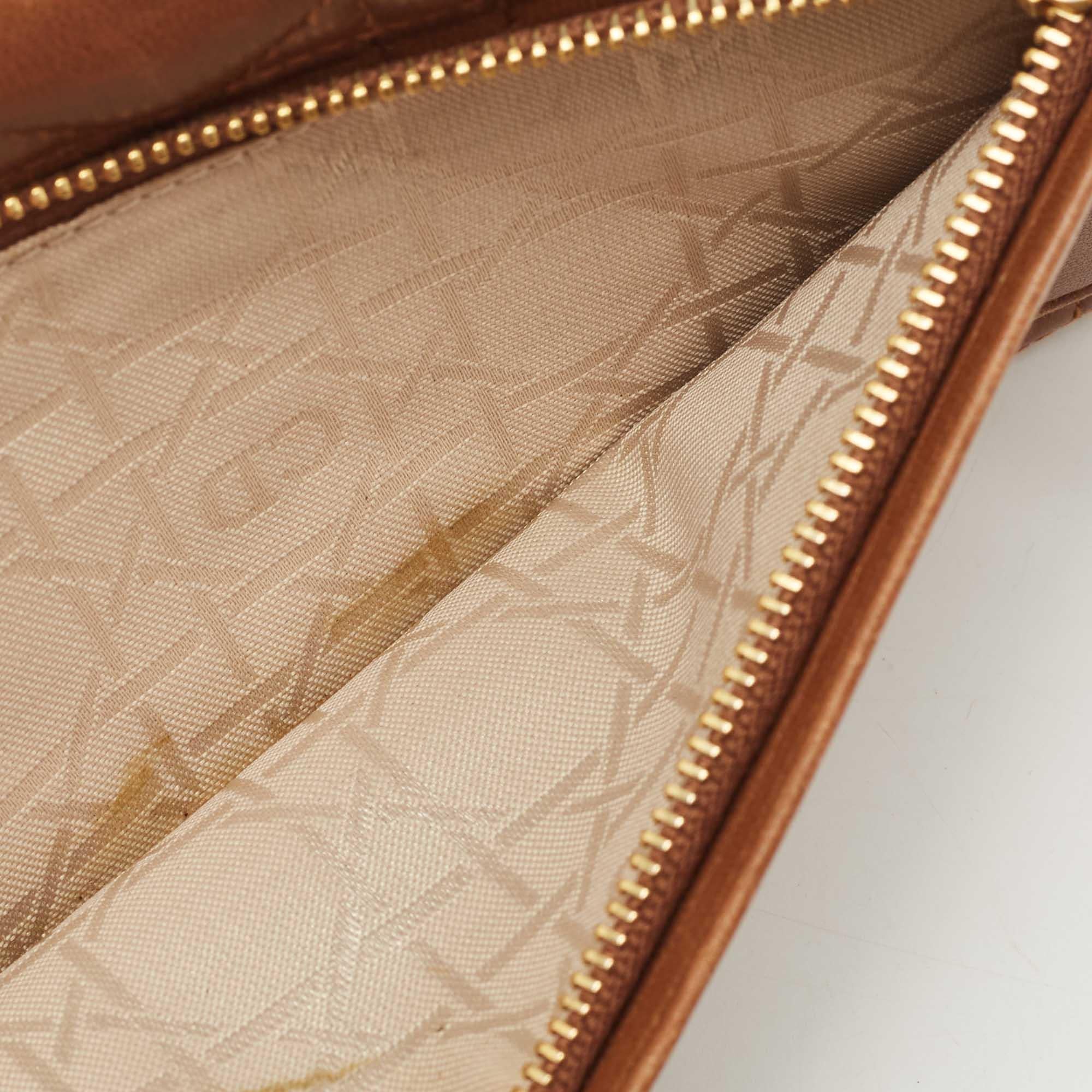 Questo portafoglio Dior è stato progettato per essere utilizzato tutti i giorni. Realizzata in pelle, la parte esterna presenta un motivo Cannage e una cerniera con motivo del marchio. L'interno, foderato in pelle e tessuto, ospita diversi scomparti