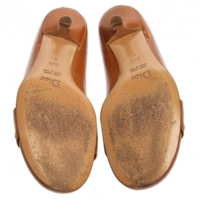 These Dior pumps are classy and stylish! They are crafted from brown leather and come accented with gold-tone buckles and grommet details at the vamps. With round toes and petite heels, these stunning pumps are complete.