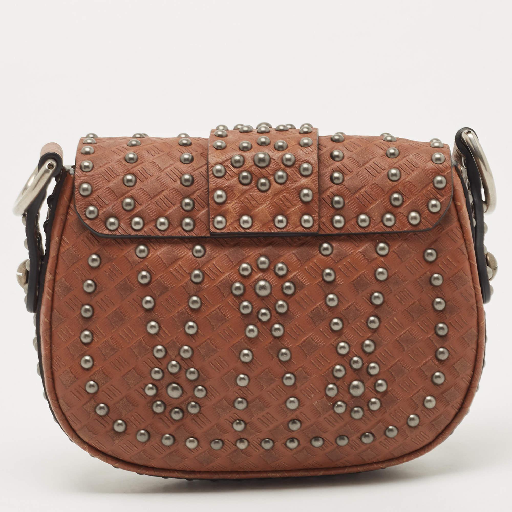 Shaped with rounded edges, this D-Fence from Dior exudes the label's penchant for making creations that are equal parts chic and distinctive. Crafted from brown leather on the exterior, this bag features studs all over, the brand label on the front,