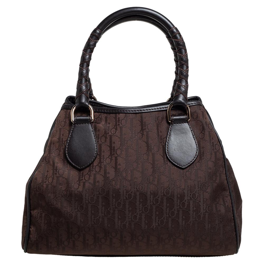 Diese Tasche von Dior ist sehr stilvoll, ohne Kompromisse beim Stil einzugehen. Mit dieser braunen Tasche können Sie einen stilvollen Look präsentieren. Sie wurde in Italien aus Oblique-Nylon und Leder gefertigt. Sie hat silberfarbene Beschläge,